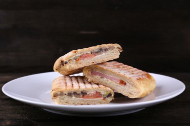 Ahşap arka plan üzerinde plaka üzerinde taze ve lezzetli sandviçler