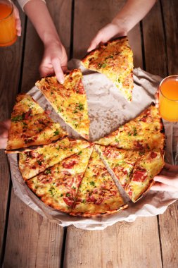 Dilim pizza alarak arkadaşlar eller