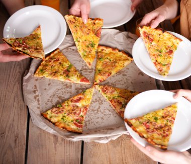 Dilim pizza alarak arkadaşlar eller