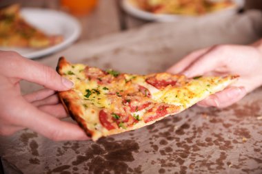 Dilim pizza alarak arkadaşlar eller