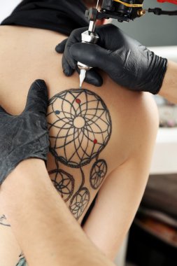 Dövme, yakın çekim yapma işlemi gösteren tattooer