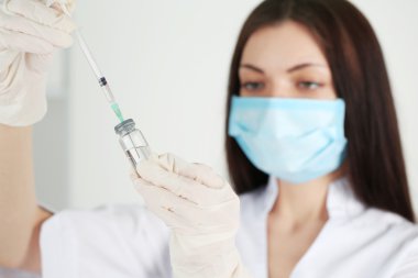 Ampul ve doktorun elinde şırınga