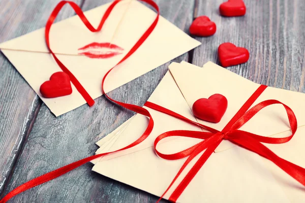 Liefdesbrieven met rood lint op houten achtergrond — Stockfoto