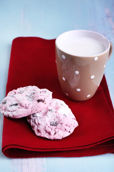 Różowy cookies i kubek z mleka na stół szczegół — Zdjęcie stockowe