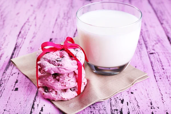 Pink cookie-kat és a pohár tejet a táblázat közelről — Stock Fotó