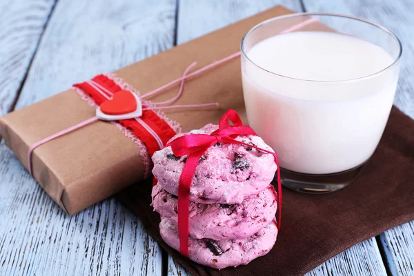 Pink cookie-kat és a pohár tejet a táblázat közelről — Stock Fotó