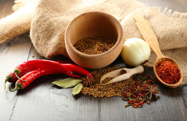 Different kinds of spices on wooden background — Stock Photo, Image