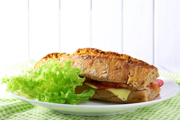 Sandwich frais et savoureux avec jambon et laitue sur fond en bois — Photo