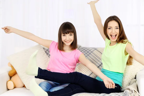 Две девушки улыбаются на домашнем фоне интерьера — стоковое фото
