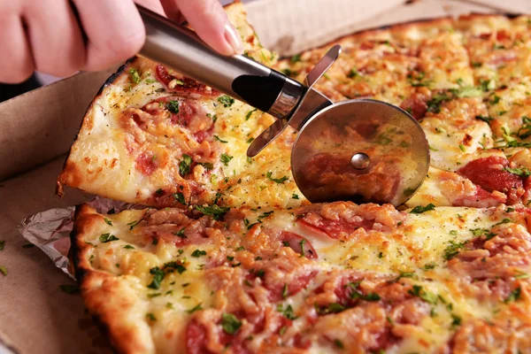 Ragazza tagliare la pizza sul tavolo da vicino — Foto Stock