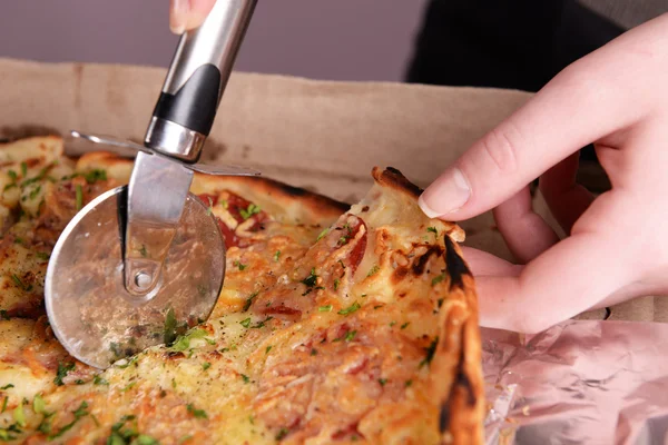 Girl cut pizza on table close up — Stock Photo, Image