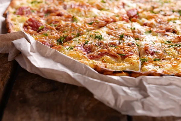 Kağıt ahşap arka plan üzerinde lezzetli pizza — Stok fotoğraf