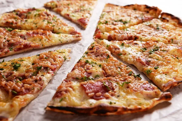 Leckere Pizza auf Papier aus nächster Nähe — Stockfoto