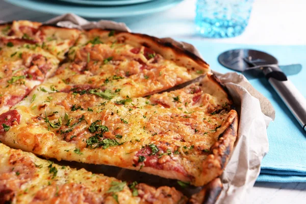 Tasty pizza with tableware on wooden table close up — Stock Photo, Image