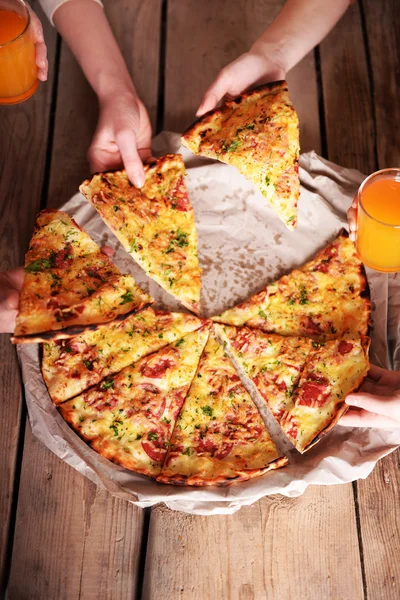 Amigos mãos tomando fatias de pizza — Fotografia de Stock