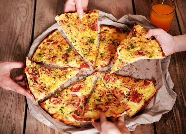 Friends hands taking slices of pizza