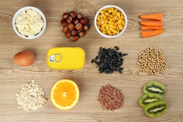 Vários produtos alimentares que contêm vitaminas em fundo de madeira — Fotografia de Stock
