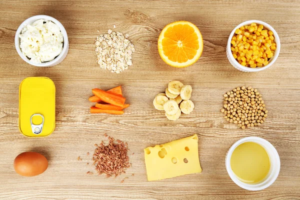 Vários produtos alimentares que contêm vitaminas em fundo de madeira — Fotografia de Stock