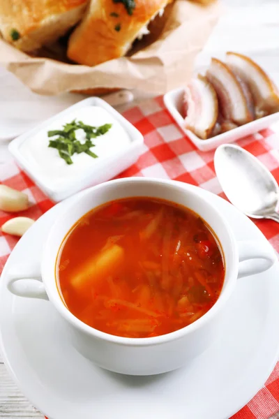 Ukrainian beetroot soup - borscht, on napkin, on wooden background — Stock Photo, Image