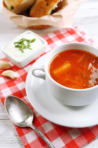 La sopa ucraniana de remolacha - borscht, sobre la servilleta, sobre el fondo de madera —  Fotos de Stock