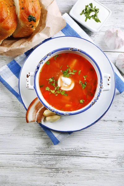 La sopa ucraniana de remolacha - borscht, sobre la servilleta azul, sobre el fondo de madera — Foto de Stock