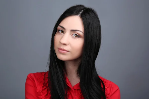 Portrait of young woman on grey background — Stock Photo, Image