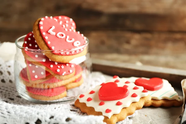 Heart shaped cookies for valentines day in glass jar on color wooden background — Stock Photo, Image