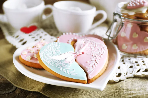 Hartvormige koekjes voor de dag van valentijnskaarten en theepot op houten achtergrond — Stockfoto