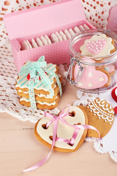 Heart shaped cookies for valentines day on plate, tea bags and card on color wooden background — Stock Photo, Image