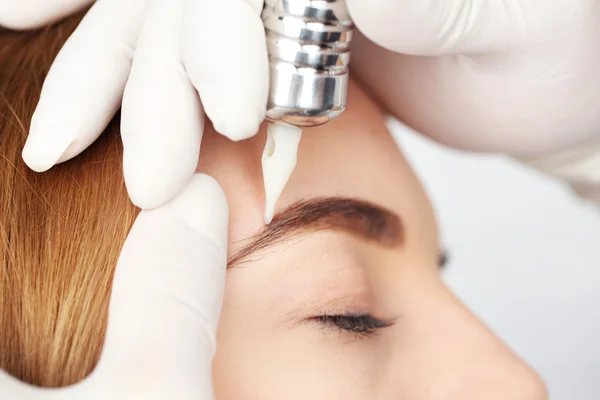 Kosmetolog att göra permanent makeup, närbild — Stockfoto