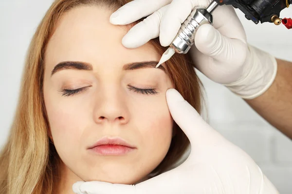 Kosmetolog att göra permanent makeup, närbild — Stockfoto