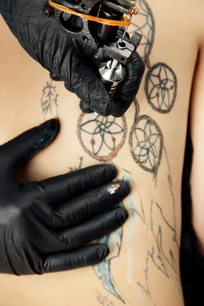 Tattooer showing process of making tattoo, close up — Stock Photo, Image