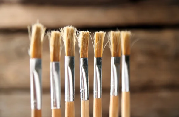 Paint brushes on old wooden background — Stock Photo, Image