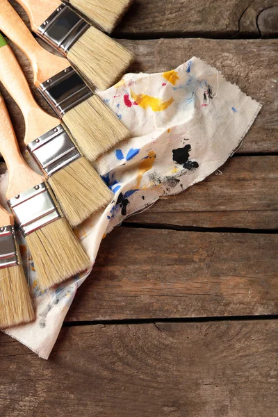 Paint brushes on old wooden background — Stock Photo, Image