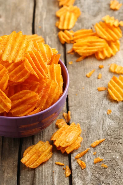 Delicious potato chips in bowl on wooden table close-up — Stock Photo, Image