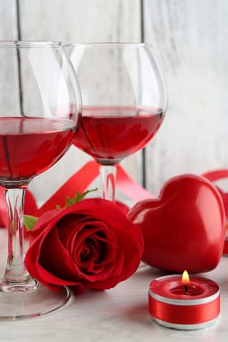 Cam, kırmızı gül ve dekoratif kalp renk ahşap arka plan üzerinde kırmızı şarap ile kompozisyon