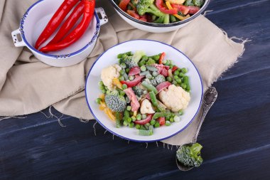 Dondurulmuş sebze peçeteye ahşap masa arka plan üzerinde plaka üzerinde