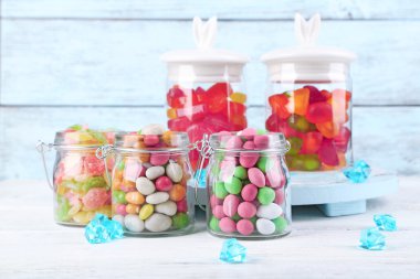 Cam Kavanoz renk ahşap arka plan üzerinde çok renkli şekerler