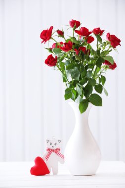 Ahşap plakalar arka plan üzerinde vazoda kırmızı gül buketi