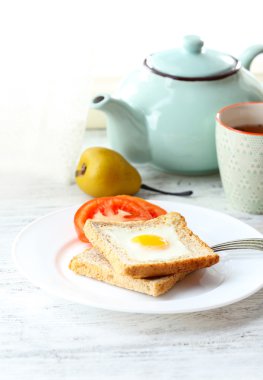 Ekmek ile çay ışık arka plan üzerinde plaka üzerinde yumurtayla karıştırılmış