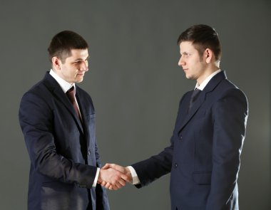 Gri arka plan üzerinde iki yakışıklı iş adamları