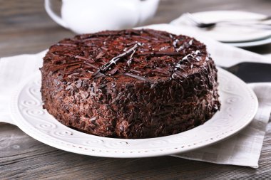 Peçete ahşap masa arka plan üzerinde plaka üzerinde lezzetli çikolatalı kek