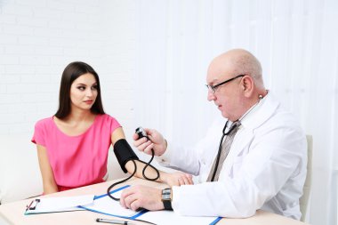 Profesyonel doktor ofisinde beyaz perde arka plan üzerinde kan basıncı ölçme