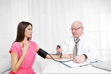 Profesyonel doktor ofisinde beyaz perde arka plan üzerinde kan basıncı ölçme