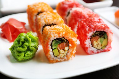 Plaka, soya sosu ve chopsticks ahşap arka plan üzerinde suşi rulo