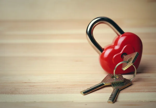 Heart-shaped padlock with key on wooden background — Stock Photo, Image