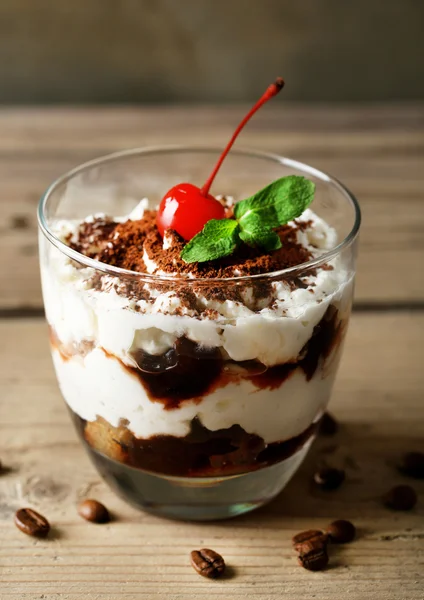 Sabroso postre tiramisú en vidrio, sobre fondo de madera — Foto de Stock