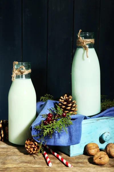 Пляшки свіжого молока з натуральним декором, на дерев'яному фоні — стокове фото