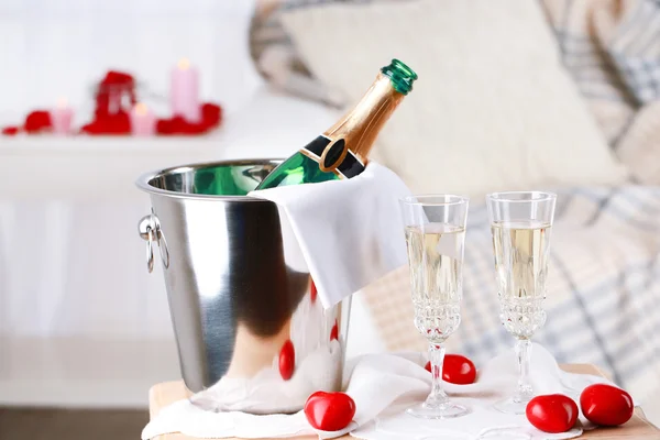 Champagnefles in emmer, glazen en rozenblaadjes voor het vieren van de dag van Valentijnskaarten — Stockfoto