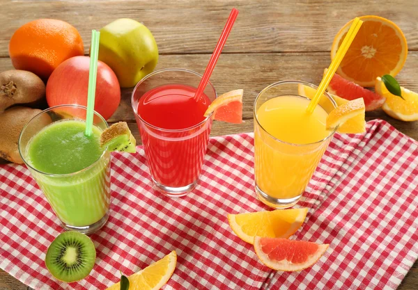 Fresh juices with fruits on wooden table — Stock Photo, Image